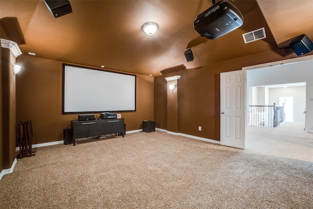 home theater room featuring decorative columns, a textured ceiling, lofted ceiling, and carpet flooring