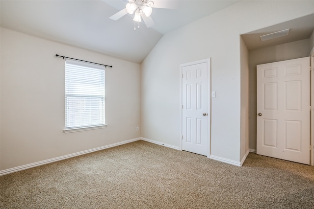 unfurnished bedroom with ceiling fan, carpet, a closet, and lofted ceiling