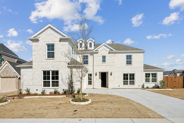 view of front of home featuring a shingled roof, brick siding, fence, and driveway