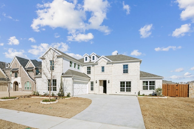 view of front of property featuring roof with shingles, a gate, fence, a garage, and driveway