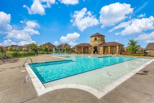 view of swimming pool with pool water feature and a patio