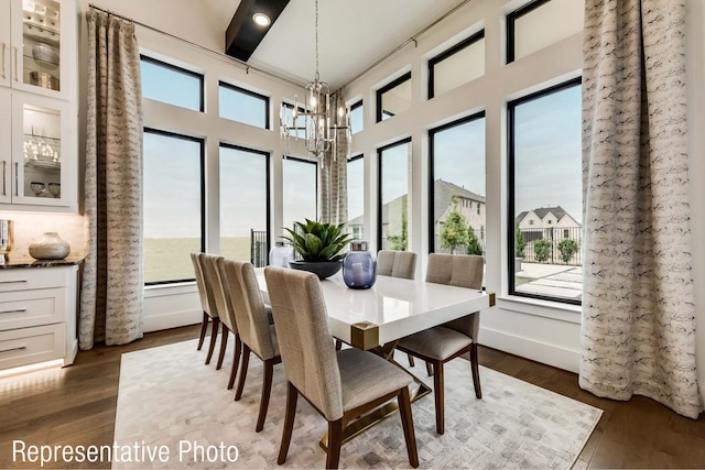 dining room with dark wood-type flooring and an inviting chandelier