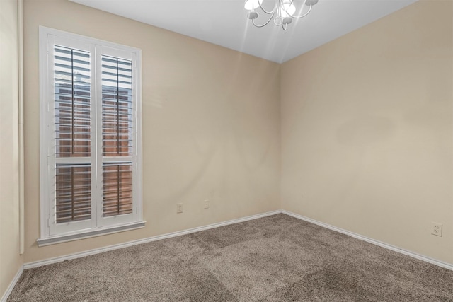 spare room with an inviting chandelier and carpet floors