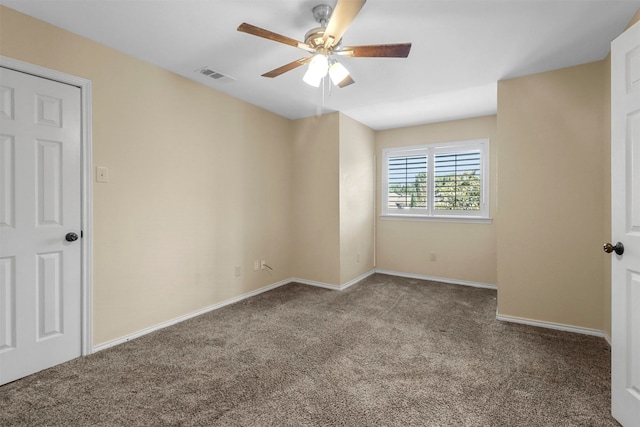 carpeted spare room with ceiling fan