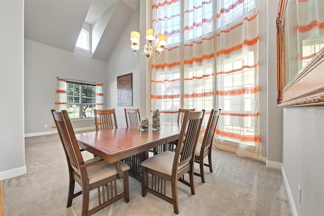 dining room featuring an inviting chandelier, light colored carpet, and high vaulted ceiling