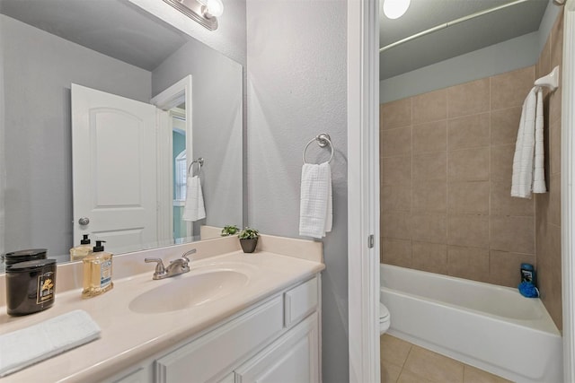 full bathroom with tile patterned flooring, vanity, toilet, and tiled shower / bath combo