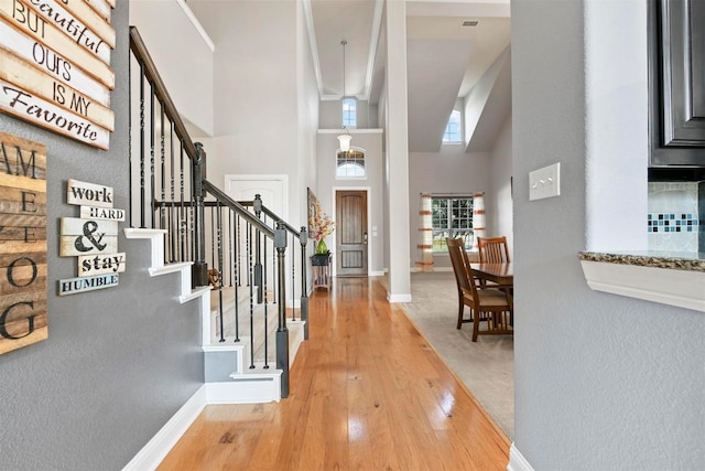 foyer entrance with hardwood / wood-style floors and lofted ceiling with beams