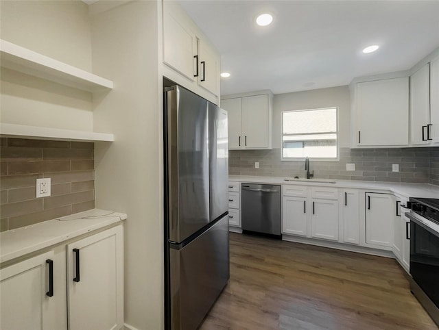 kitchen featuring dark wood-style floors, appliances with stainless steel finishes, a sink, and white cabinetry