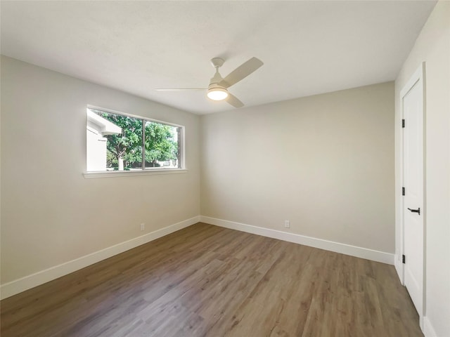 spare room with light wood-style floors, ceiling fan, and baseboards