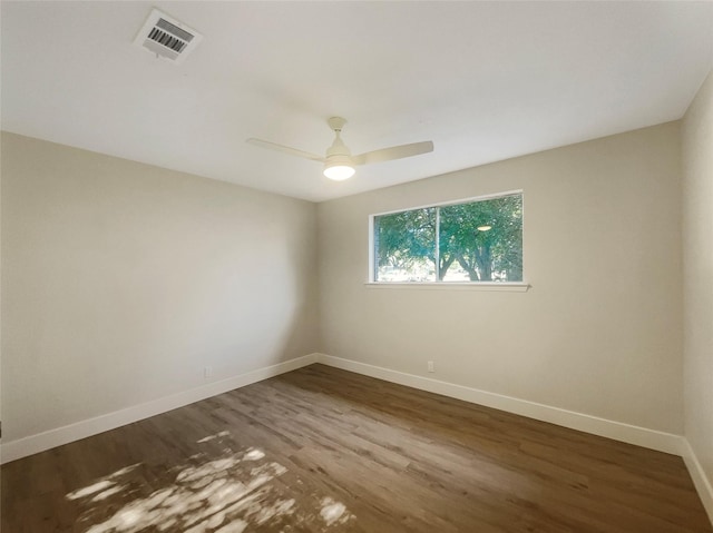 unfurnished room with baseboards, visible vents, ceiling fan, and wood finished floors