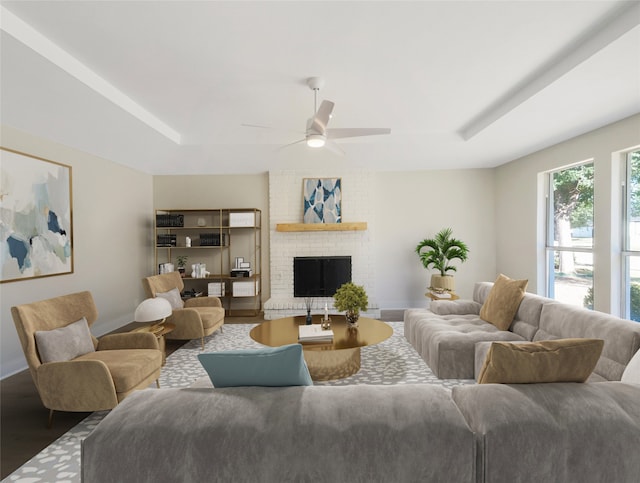 living room with brick wall, dark wood-type flooring, ceiling fan, and a fireplace