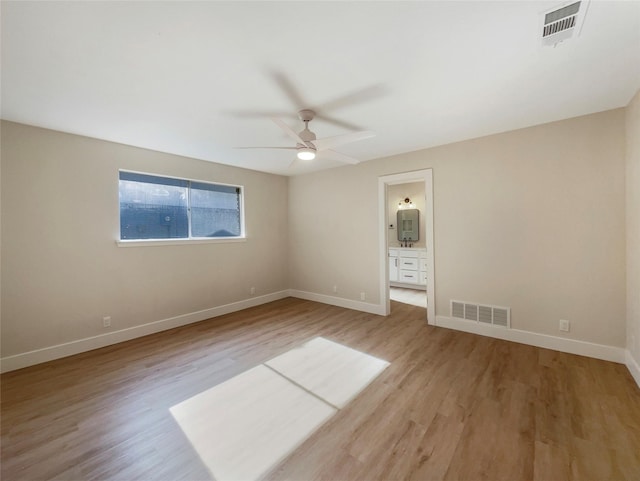 spare room featuring baseboards, visible vents, and light wood finished floors