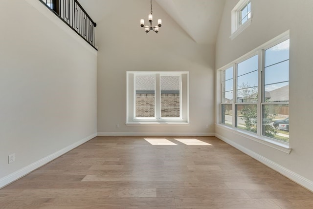 1029 Bleriot Dr, Fate, TX 75087 - unfurnished dining area featuring a chandelier, light wood-style floors, and high vaulted ceiling