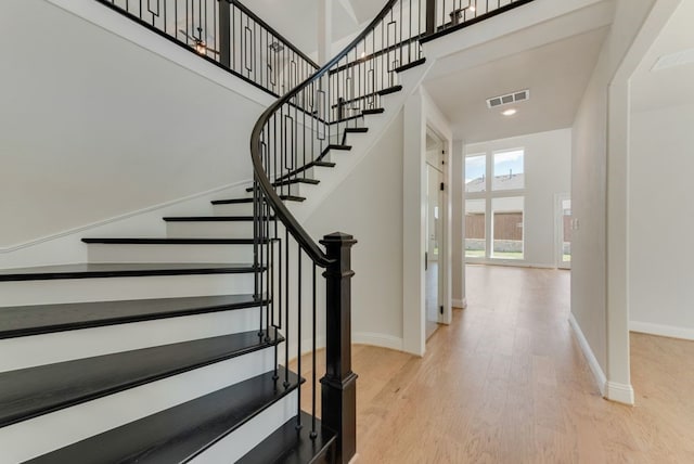 1029 Bleriot Dr, Fate, TX 75087 - staircase featuring wood finished floors, a towering ceiling, and recessed lighting