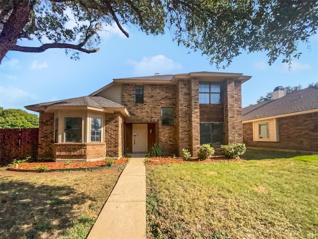 view of front of property featuring fence, a front lawn, and brick siding