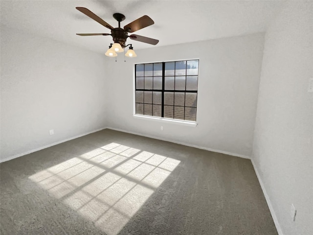 carpeted empty room with a ceiling fan and baseboards