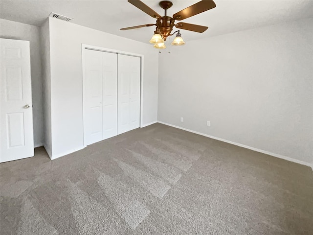 unfurnished bedroom featuring carpet floors, a closet, visible vents, a ceiling fan, and baseboards