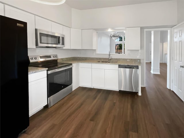 kitchen featuring stainless steel appliances, dark wood-type flooring, a sink, and white cabinets