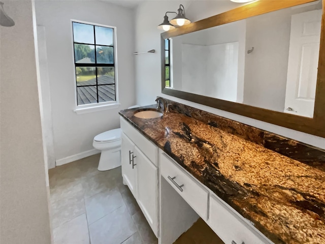 bathroom with tile patterned flooring, baseboards, vanity, and toilet