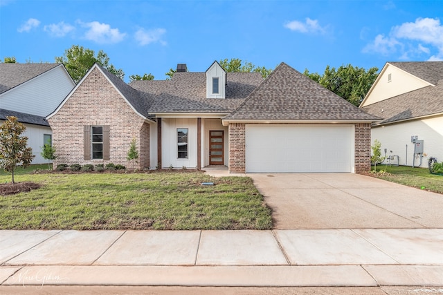 view of front of home with a front lawn, brick siding, driveway, and an attached garage