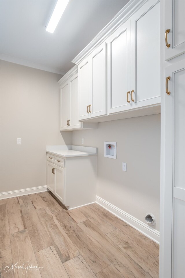 washroom featuring cabinets, hookup for a washing machine, and light hardwood / wood-style flooring