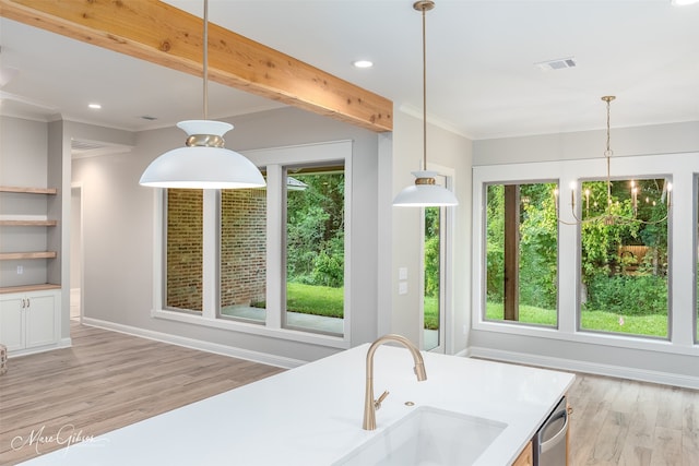 kitchen featuring beamed ceiling, light hardwood / wood-style floors, plenty of natural light, and hanging light fixtures