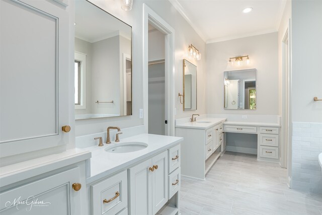 full bath featuring crown molding, two vanities, and a sink