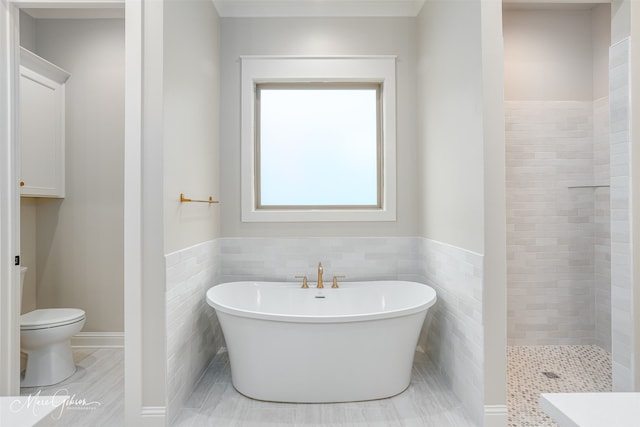 bathroom featuring a soaking tub, tiled shower, tile walls, and toilet