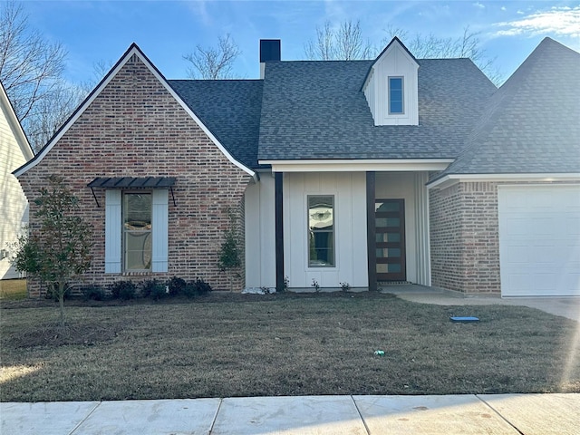 view of front of home featuring brick siding, a shingled roof, an attached garage, board and batten siding, and a front yard