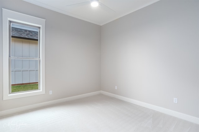 unfurnished room with light carpet, crown molding, a ceiling fan, and baseboards