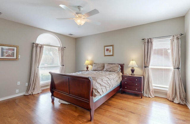 bedroom featuring light wood-type flooring, multiple windows, and ceiling fan