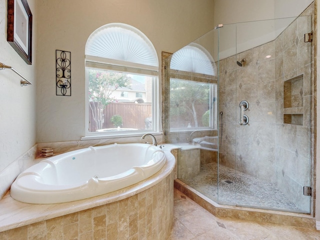 bathroom with tile patterned flooring, a wealth of natural light, and shower with separate bathtub