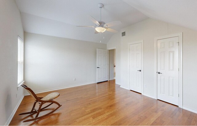 unfurnished room featuring plenty of natural light, ceiling fan, vaulted ceiling, and light hardwood / wood-style floors