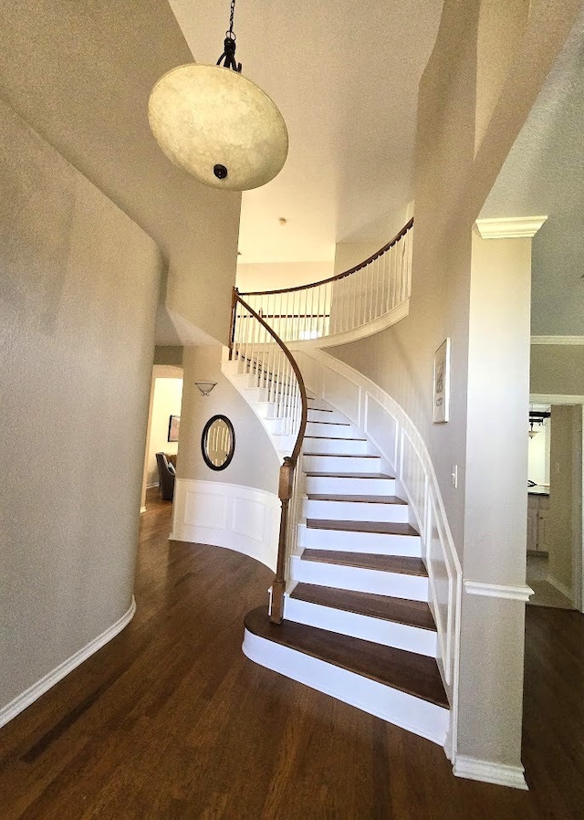 stairway featuring a high ceiling and hardwood / wood-style floors