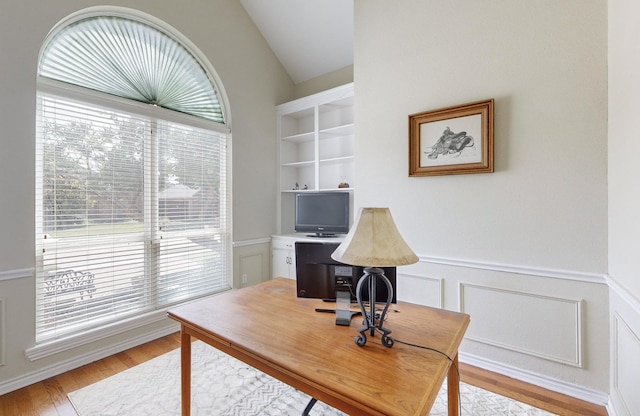 home office with lofted ceiling and light hardwood / wood-style flooring