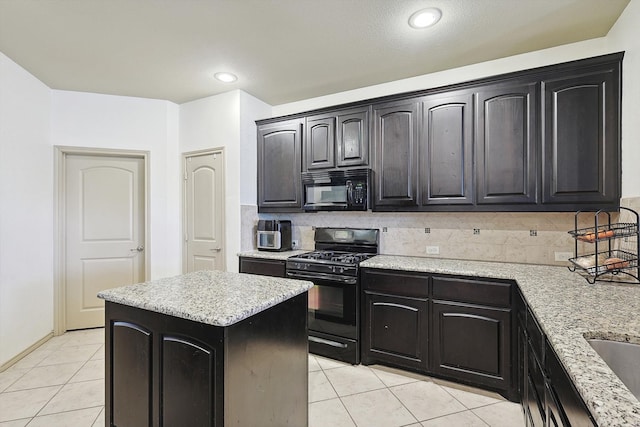 kitchen featuring tasteful backsplash, black appliances, light stone countertops, and a kitchen island