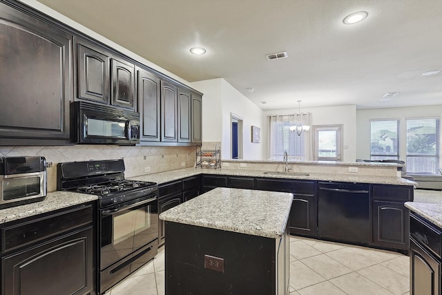 kitchen with black appliances, sink, a center island, kitchen peninsula, and an inviting chandelier