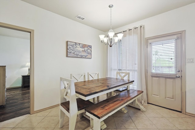 dining space featuring light hardwood / wood-style floors and a chandelier