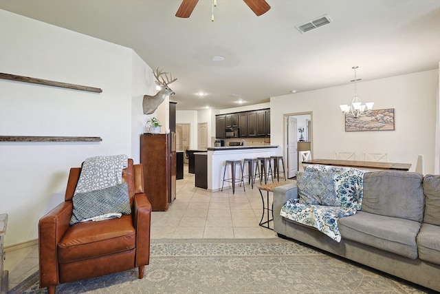 tiled living room featuring ceiling fan with notable chandelier