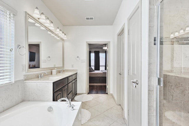 bathroom with vanity, separate shower and tub, a healthy amount of sunlight, and tile patterned floors