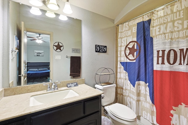 bathroom with vanity, walk in shower, toilet, and ceiling fan