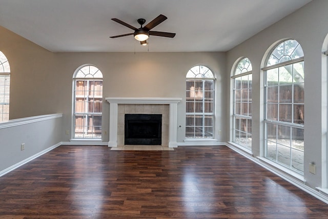 unfurnished living room featuring a healthy amount of sunlight, dark hardwood / wood-style floors, and a fireplace