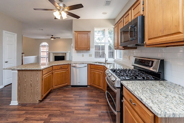 kitchen featuring stainless steel appliances, dark hardwood / wood-style floors, decorative backsplash, and ceiling fan