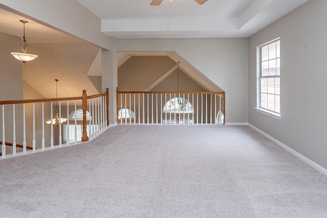 carpeted empty room with ceiling fan with notable chandelier and vaulted ceiling