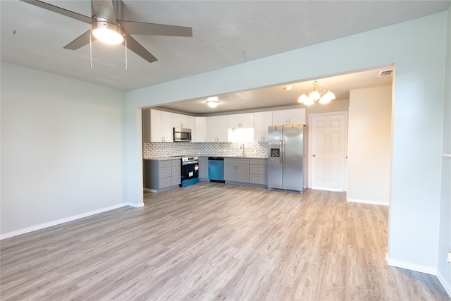 unfurnished living room featuring light wood-type flooring, ceiling fan with notable chandelier, and sink