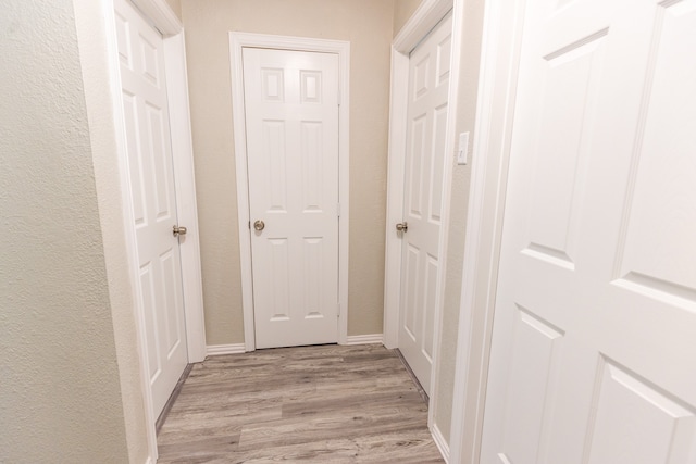 corridor with light hardwood / wood-style flooring