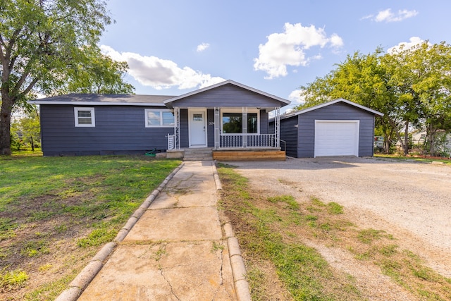 single story home with a front yard, a garage, covered porch, and an outbuilding