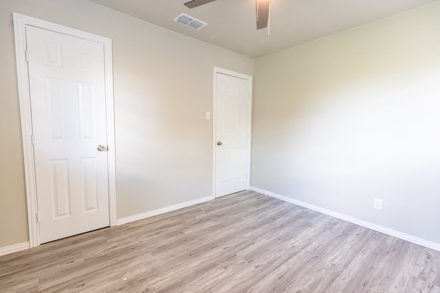 empty room with ceiling fan and light hardwood / wood-style flooring