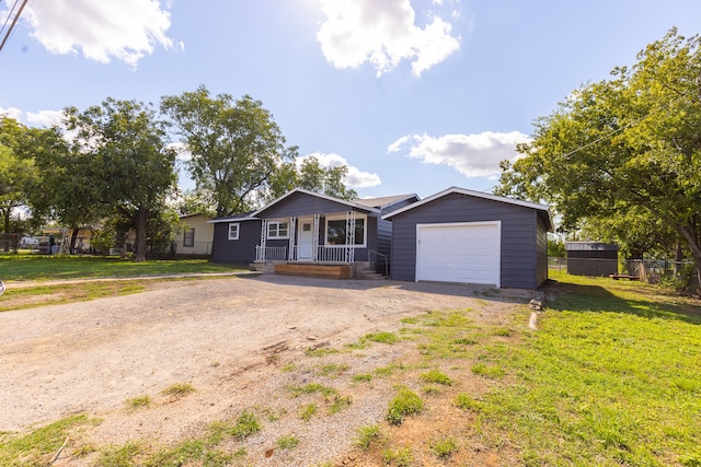 ranch-style home featuring a front lawn, covered porch, and a garage