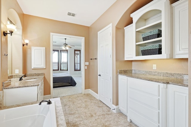 bathroom featuring vanity, a bath, ceiling fan, and tile patterned floors